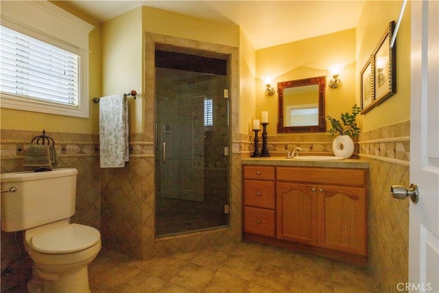 bathroom featuring an enclosed shower, vanity, toilet, and tile walls