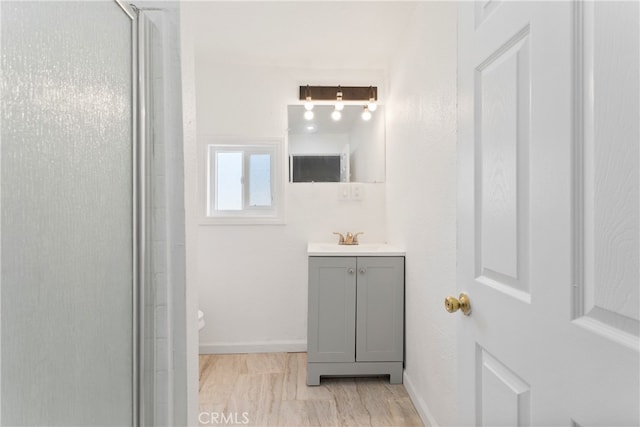 bathroom featuring vanity, a shower with shower door, and toilet