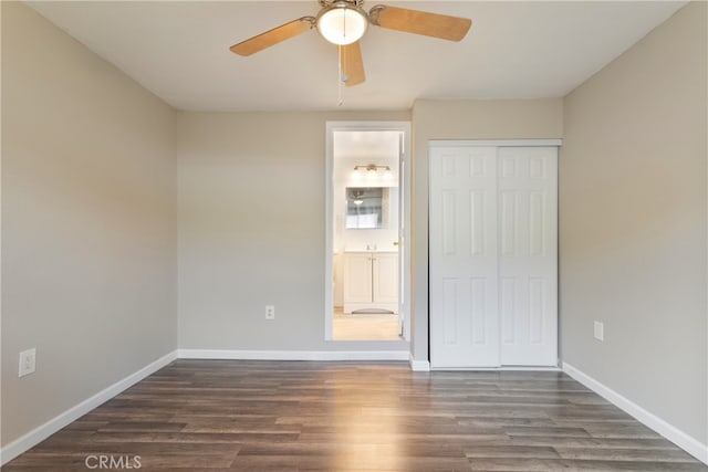 unfurnished bedroom featuring dark wood-type flooring, ceiling fan, a closet, and connected bathroom