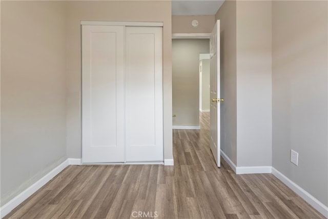 unfurnished bedroom with hardwood / wood-style flooring and a closet