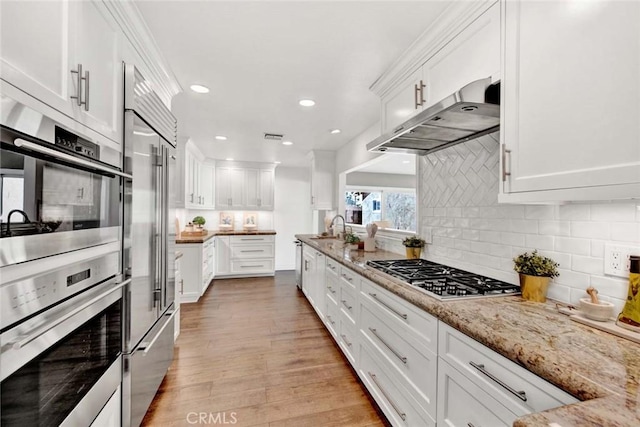 kitchen featuring white cabinets, appliances with stainless steel finishes, and light hardwood / wood-style floors