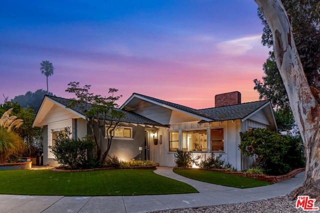 ranch-style home with a yard