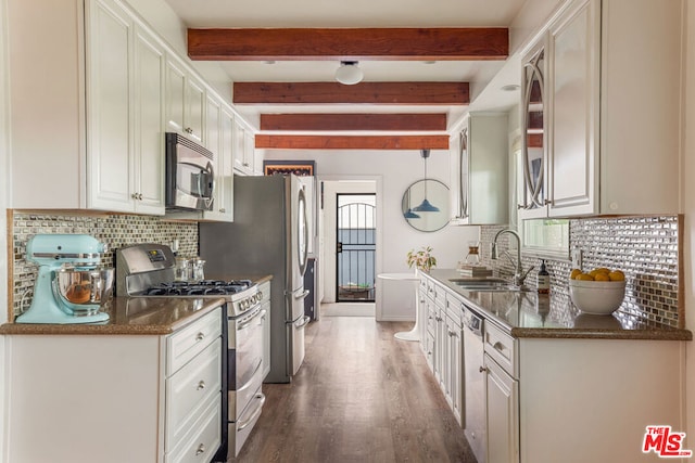 kitchen with white cabinetry, sink, stainless steel appliances, and decorative light fixtures