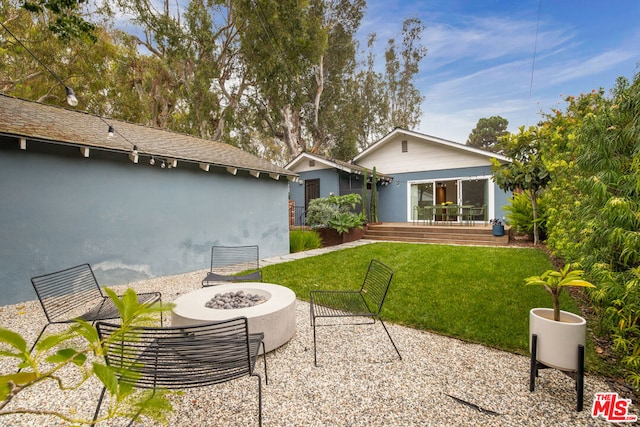 rear view of house with a lawn, a patio area, and an outdoor fire pit