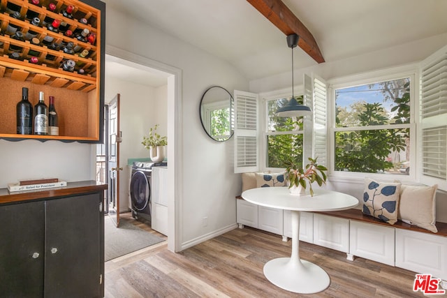 dining area featuring lofted ceiling with beams, wood-type flooring, breakfast area, and separate washer and dryer