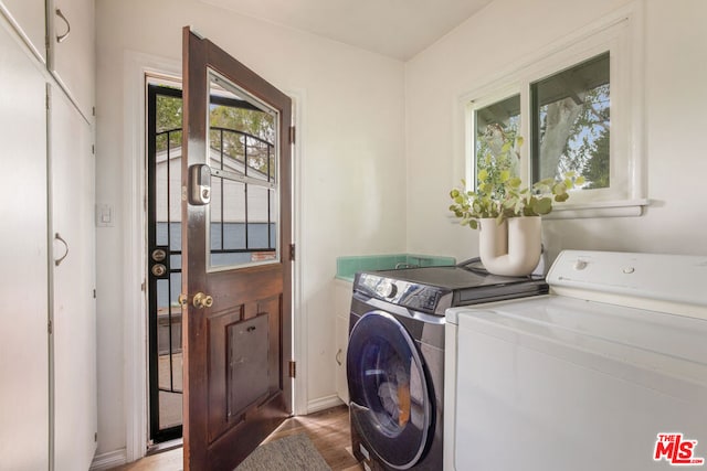 washroom with washing machine and dryer and light hardwood / wood-style flooring