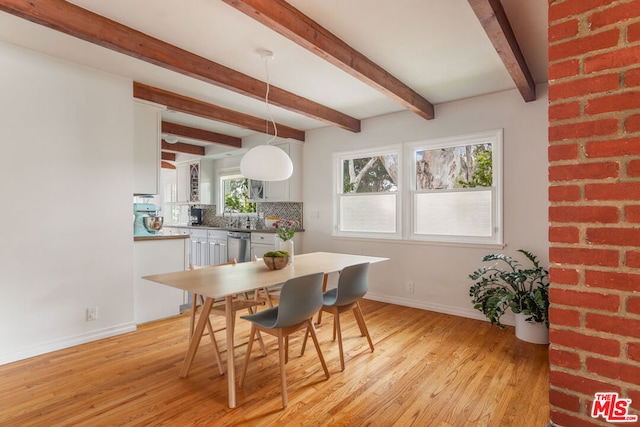 dining room featuring beam ceiling and light hardwood / wood-style flooring