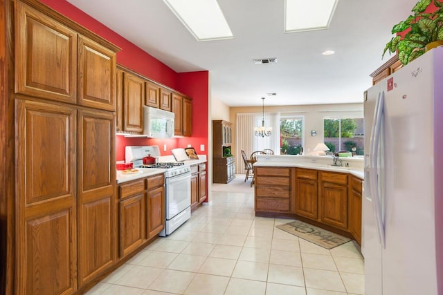 kitchen with an inviting chandelier, white appliances, light tile patterned flooring, pendant lighting, and sink