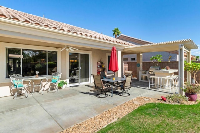 view of patio featuring ceiling fan, exterior bar, area for grilling, and a pergola