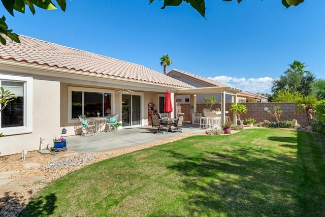 rear view of property featuring a lawn and a patio