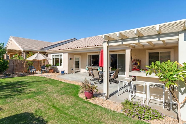 back of property with a pergola, a yard, and a patio