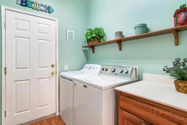 laundry room featuring washing machine and dryer and hardwood / wood-style flooring