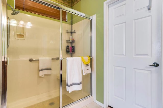 bathroom with tile patterned flooring and a shower with door