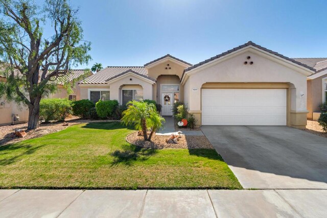 mediterranean / spanish house with a garage and a front yard