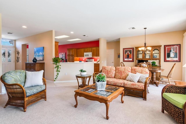 living room featuring light carpet and a notable chandelier