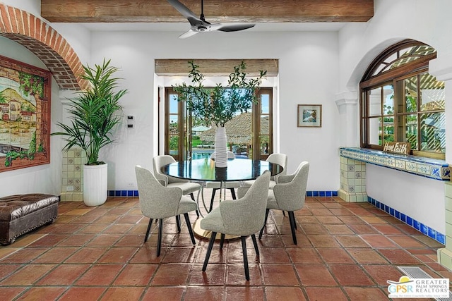 dining area featuring beam ceiling, dark tile patterned floors, and ceiling fan