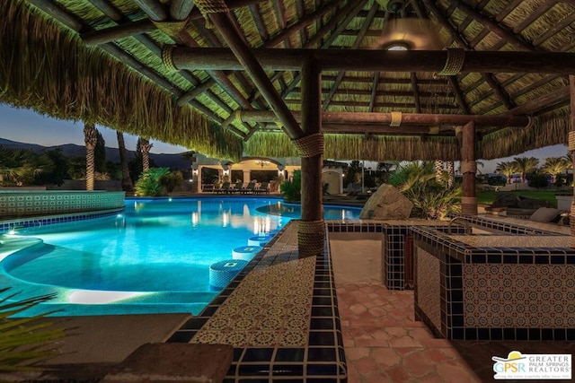 view of swimming pool with a gazebo and a mountain view