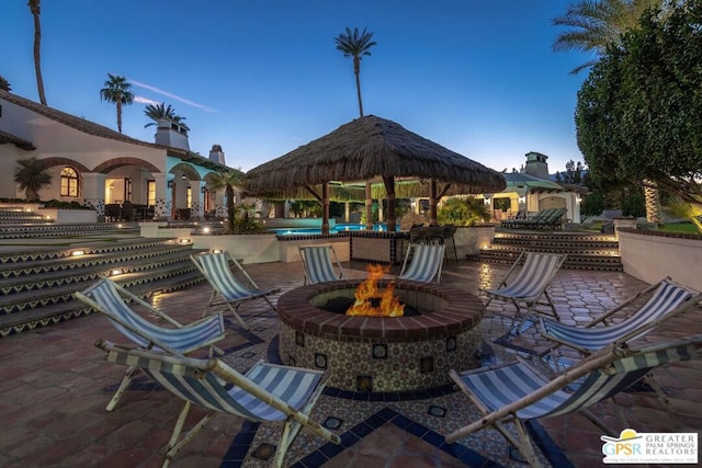 patio terrace at dusk with a gazebo and a fire pit