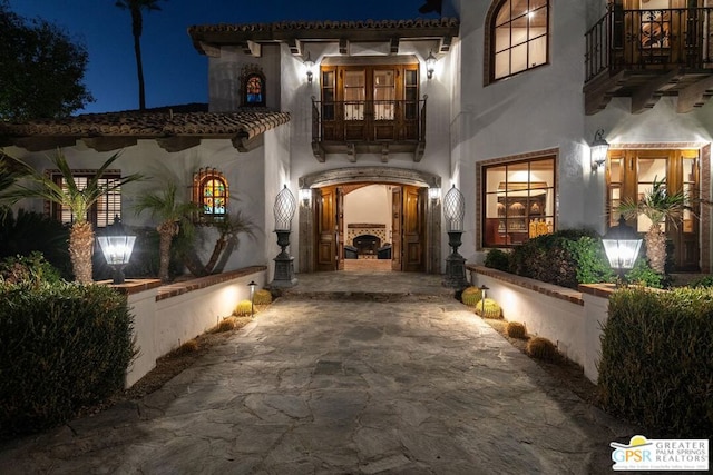 exterior entry at night with a balcony