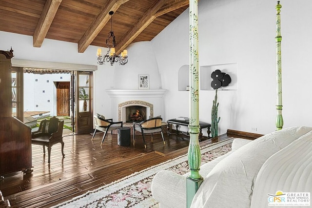 living room with wooden ceiling, dark wood-type flooring, an inviting chandelier, lofted ceiling with beams, and a fireplace