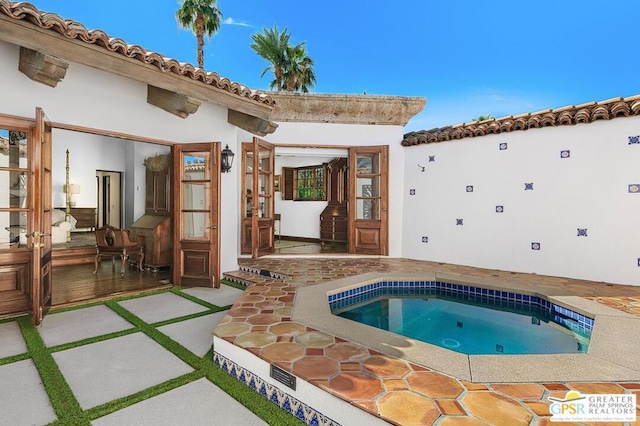 view of swimming pool featuring an in ground hot tub and a patio