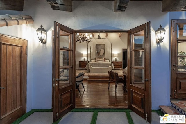 bedroom with hardwood / wood-style flooring and an inviting chandelier