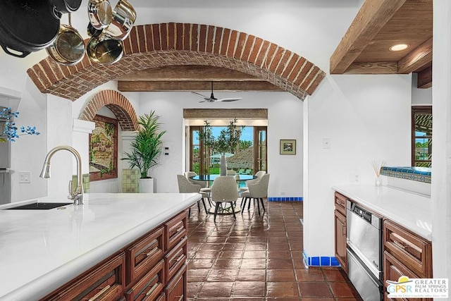 kitchen with beamed ceiling, ceiling fan, and sink