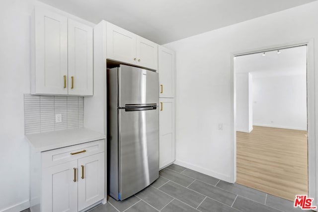 kitchen featuring white cabinetry, stainless steel refrigerator, and dark hardwood / wood-style floors