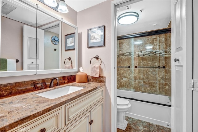 full bathroom featuring vanity, toilet, and shower / bath combination with glass door