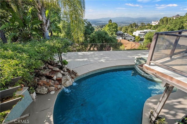 view of swimming pool with a patio, a mountain view, and pool water feature