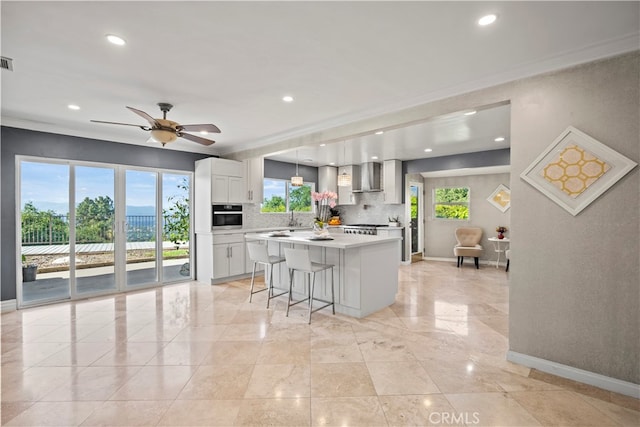 kitchen with oven, a center island, plenty of natural light, and white cabinets