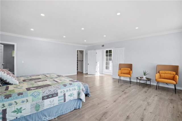 bedroom with light hardwood / wood-style flooring and crown molding