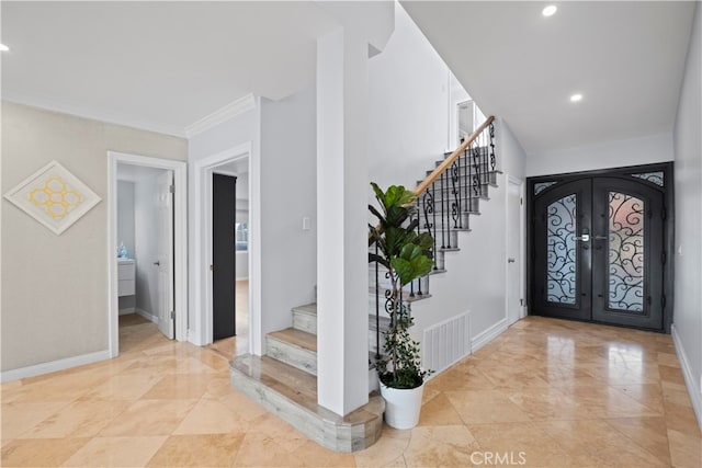 foyer featuring french doors and crown molding