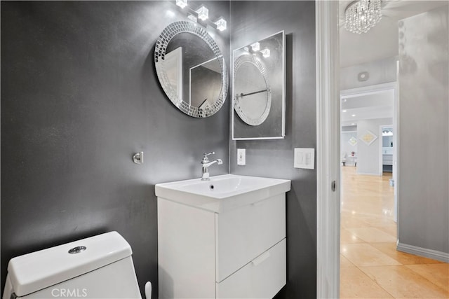 bathroom with vanity, toilet, a chandelier, and tile patterned flooring