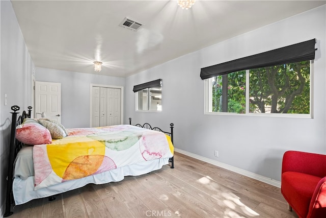 bedroom with light hardwood / wood-style flooring and a closet