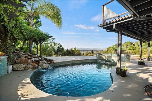 view of swimming pool featuring pool water feature, a mountain view, and a patio area