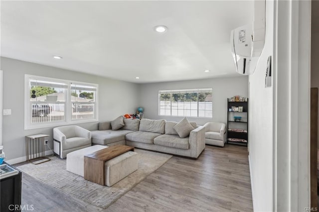 living room with light wood-type flooring and a wall unit AC