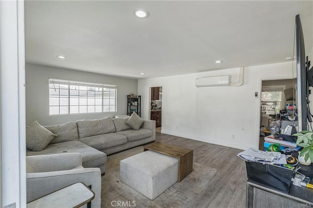 living room featuring wood-type flooring and an AC wall unit