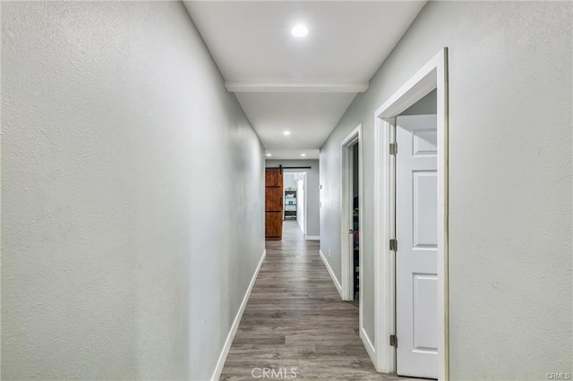 corridor featuring hardwood / wood-style flooring and a barn door