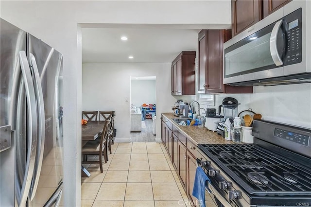 kitchen featuring light tile patterned flooring, stainless steel appliances, and sink