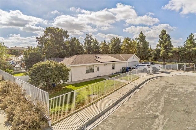 single story home featuring a front yard and solar panels