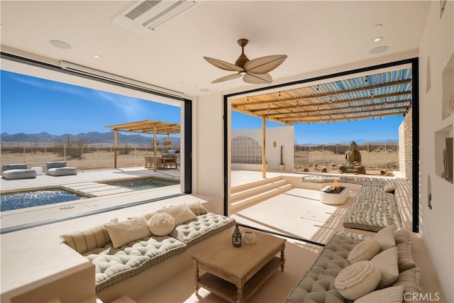 interior space featuring ceiling fan, a healthy amount of sunlight, and a mountain view