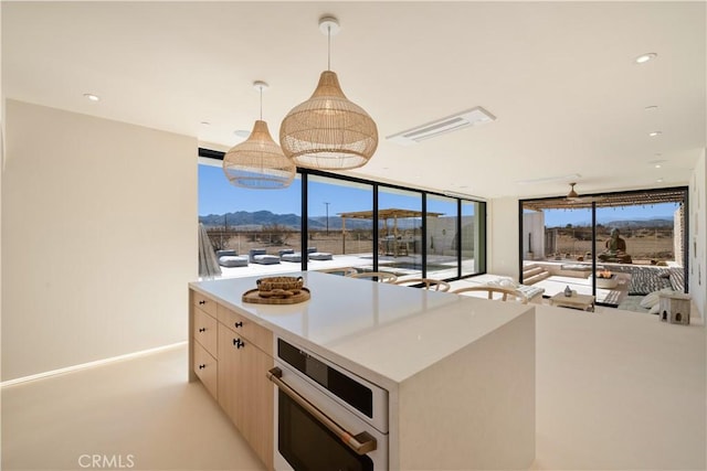 kitchen featuring a mountain view, stainless steel appliances, and hanging light fixtures