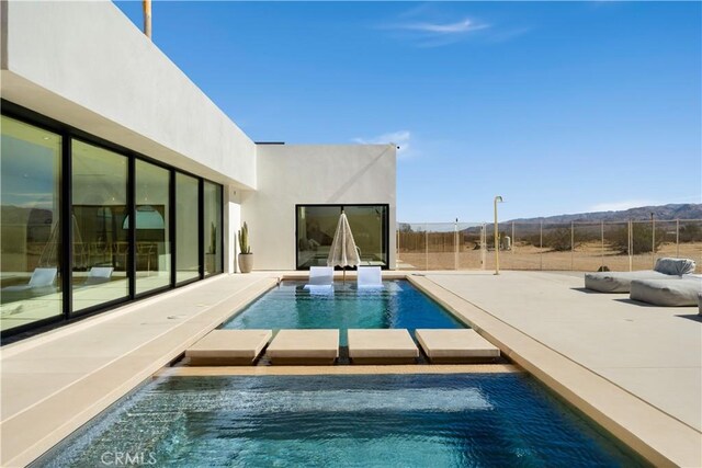 view of pool featuring a mountain view and a patio