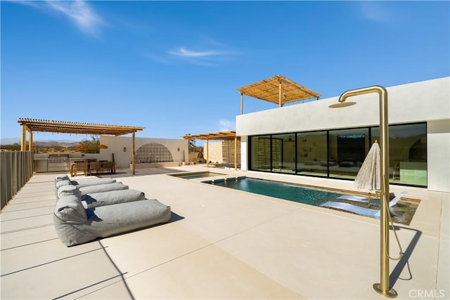 view of pool with an outdoor kitchen, a patio area, and a pergola