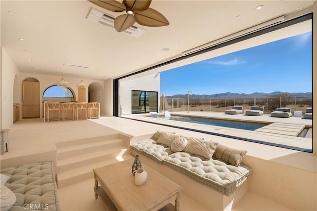 interior space featuring carpet flooring, a mountain view, and ceiling fan