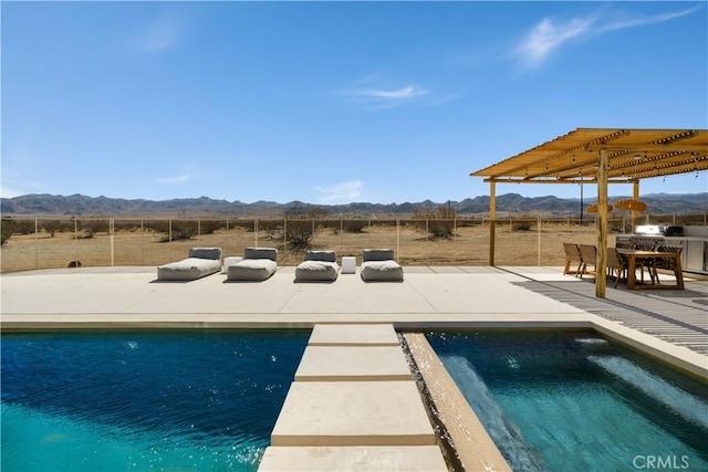 view of pool featuring a patio area, a mountain view, and a rural view