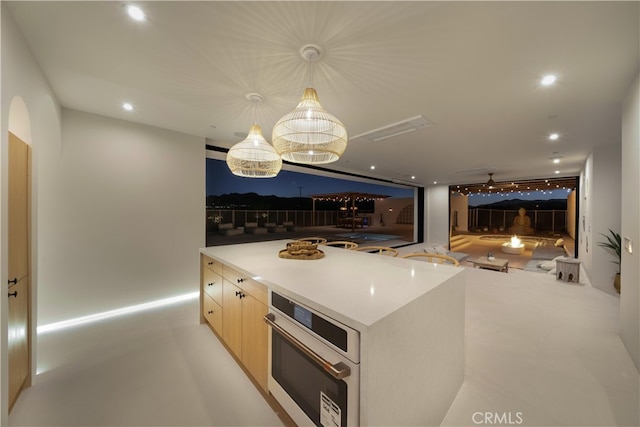 kitchen featuring oven, hanging light fixtures, and a kitchen island