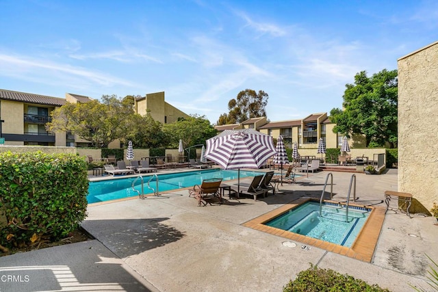 view of swimming pool with a hot tub and a patio area