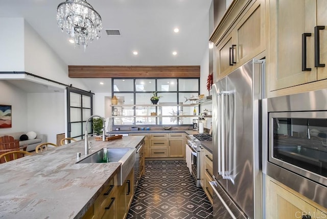 51 Catspaw, Coronado, CA 92118 - kitchen featuring visible vents, dark stone counters, a barn door, a sink, and high quality appliances